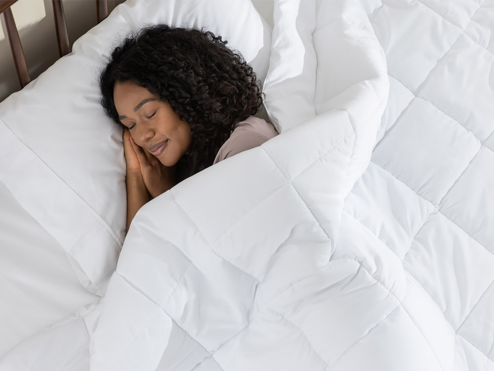 Woman sleeping peacefully, covered by her down alternative duvet