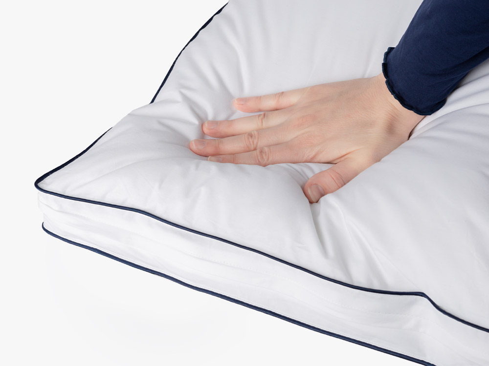Hand pressing into the plush surface of the Adjustable Memory Foam Pillow