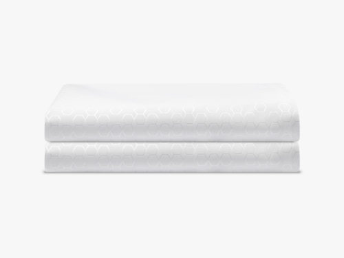 Two Pillow protectors with light circular patterns sit atop one another, neatly folded.