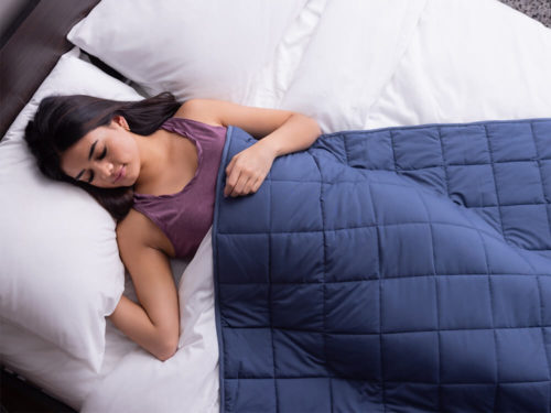 Woman sleeping peacefully with Classic Weighted Blanket draped over her body