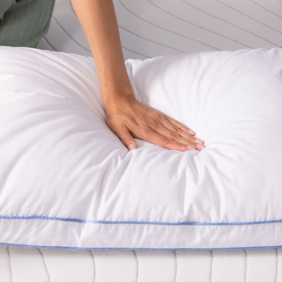 A hand pushing into a pillow showing how soft it is.
