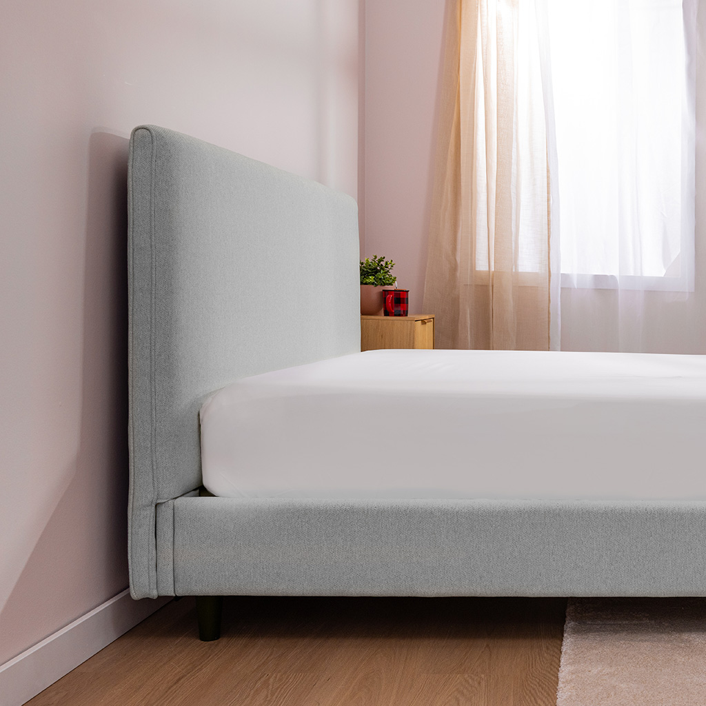 Bed frame's headboard sits flush against the wall