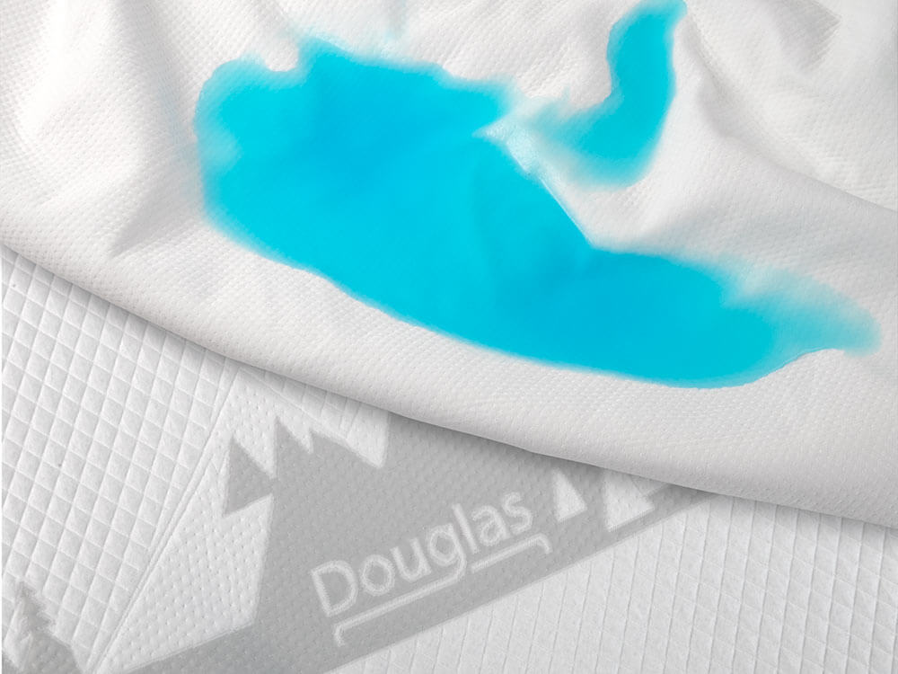 Mattress protector absorbing blue liquid while mattress stays clean.