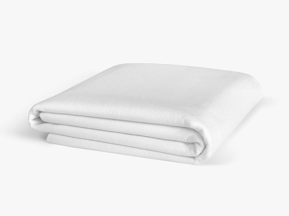 Folded white mattress protector against a white background.
