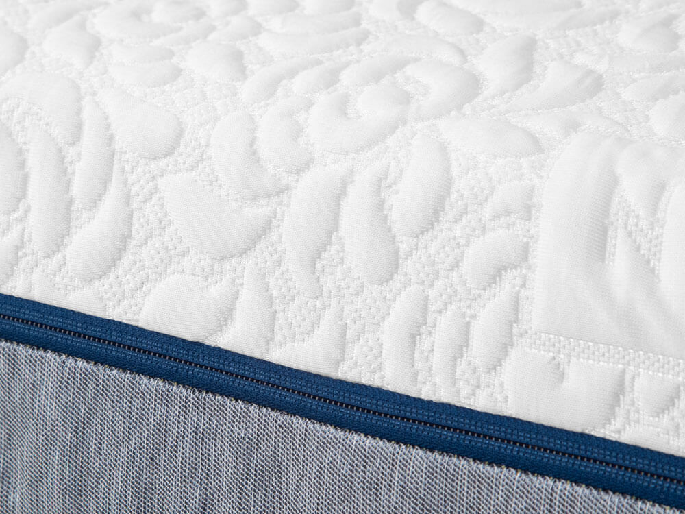Closeup of the white quilted Tencel cover and blue zipper of the Novosbed premium memory foam mattress